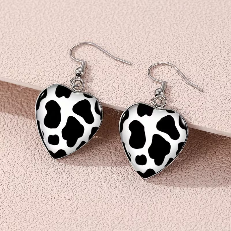 A Set of Heart-Shaped Earrings Featuring a Cow Print Design