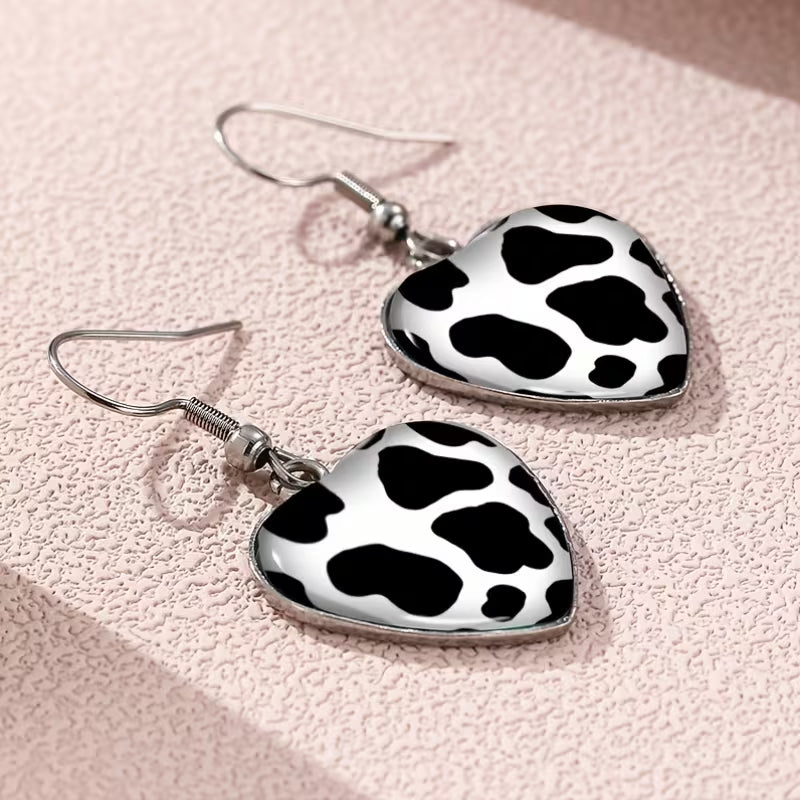 A Set of Heart-Shaped Earrings Featuring a Cow Print Design