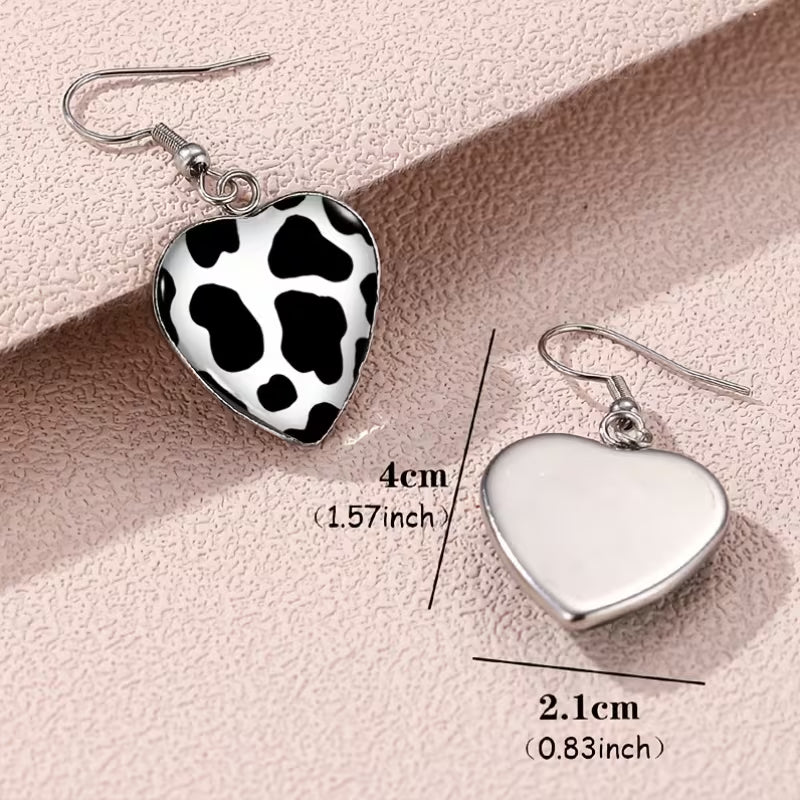 A Set of Heart-Shaped Earrings Featuring a Cow Print Design